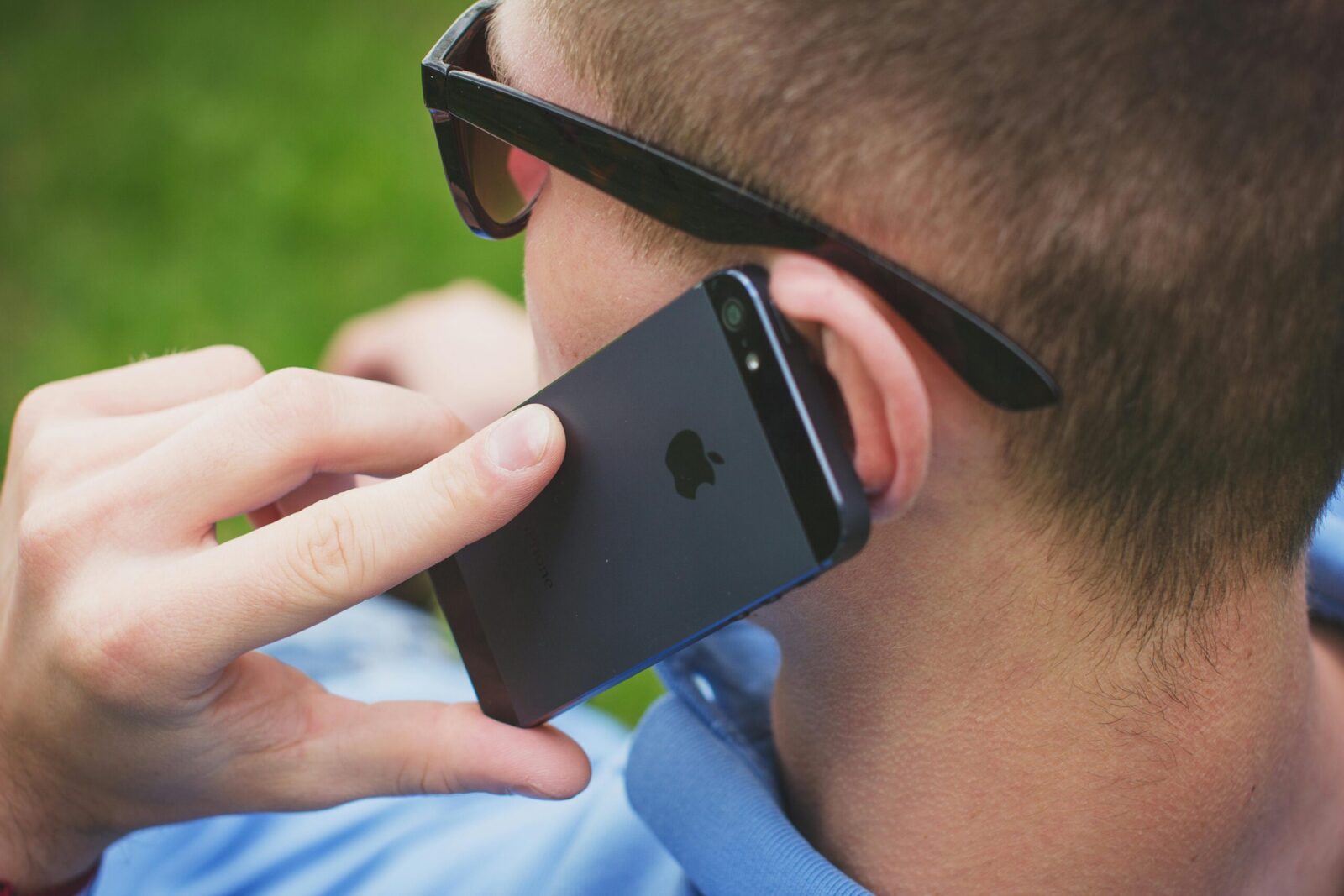 Man making a call outdoors using smartphone, focused on communication.